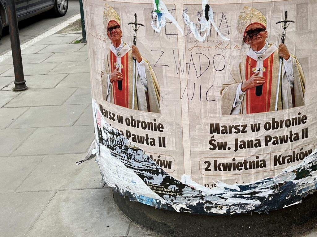 Zniszczone plakaty zapraszające na Marsz w obronie św. Jana Pawła II w Krakowie